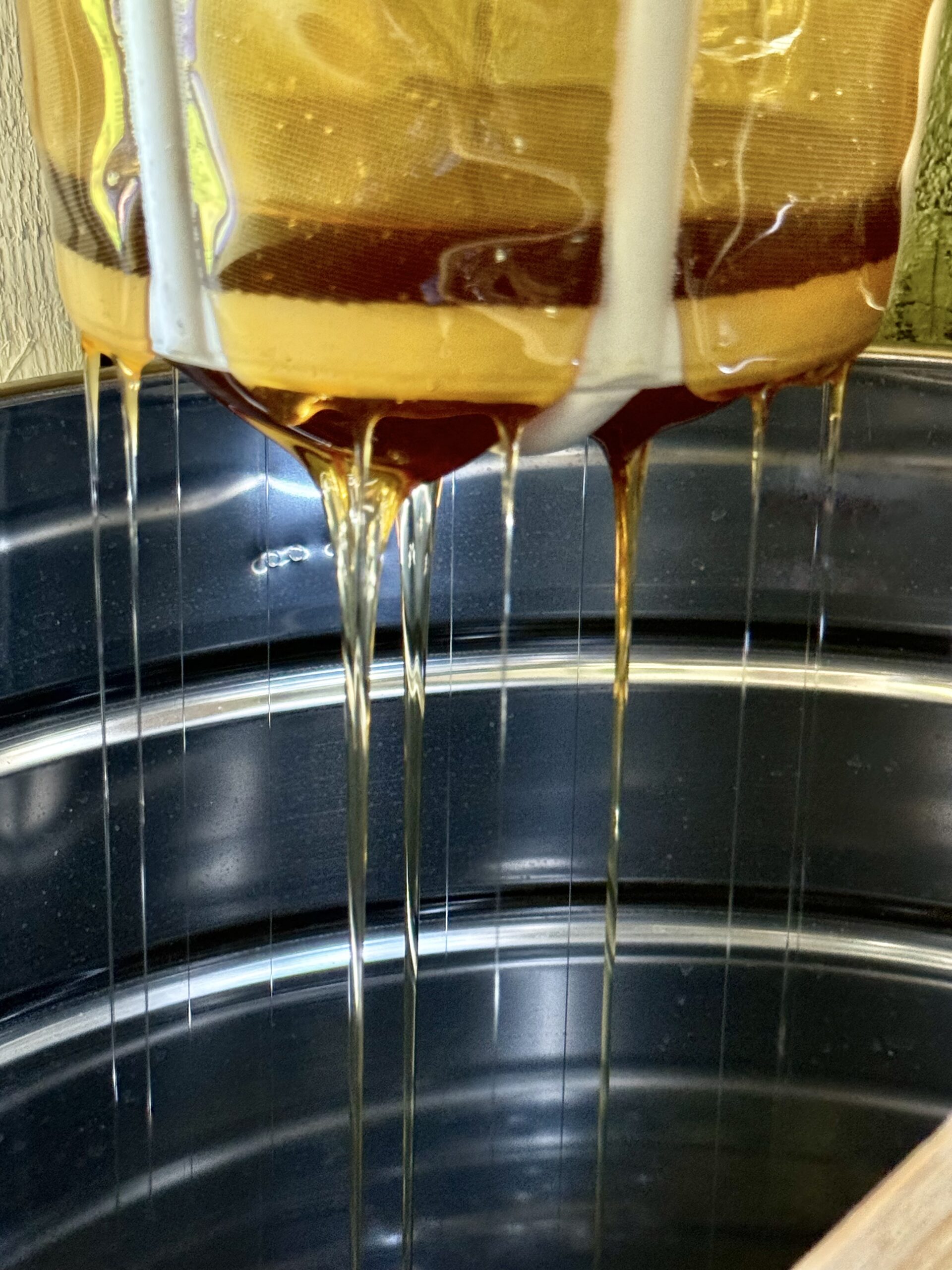 miód spływa z miodarki podczas miodobrania