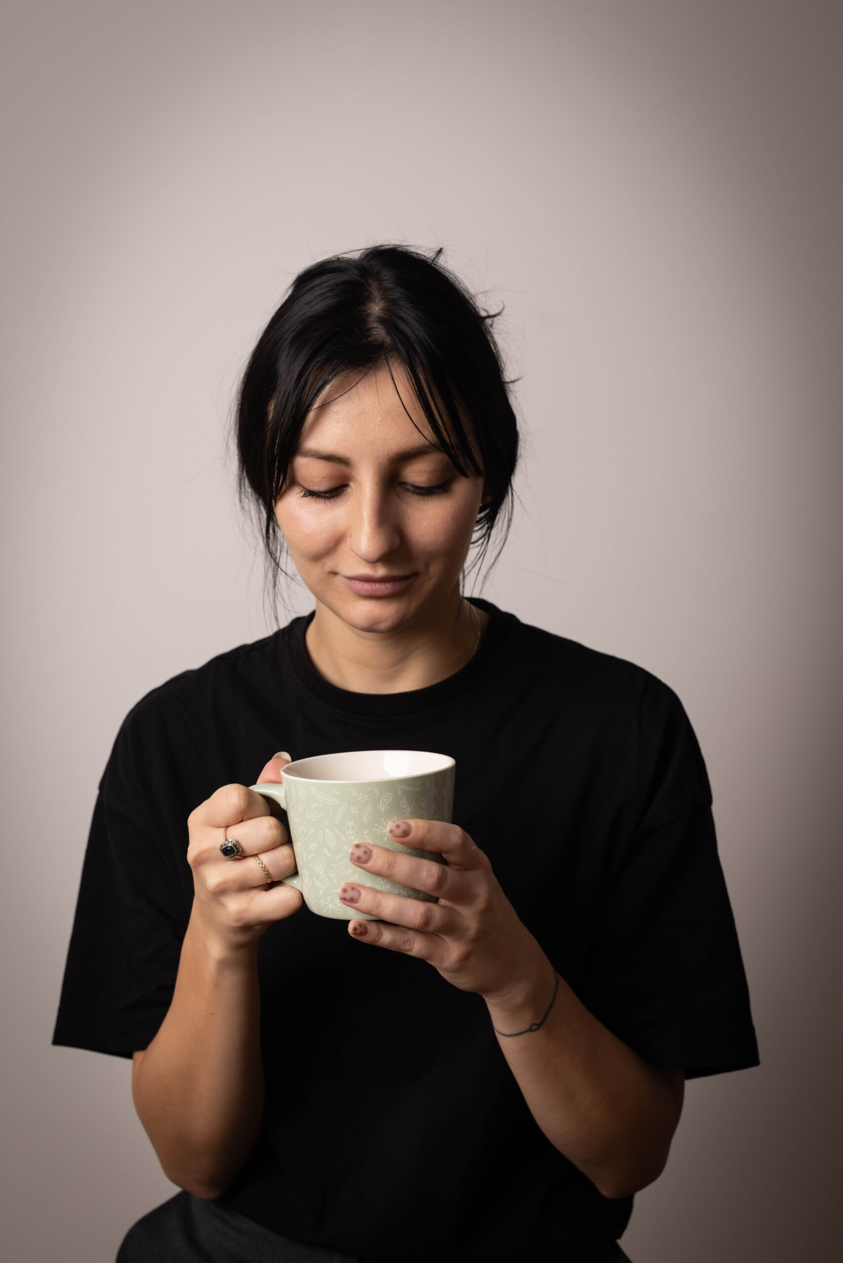 Dziewczyna brunetka siedzi z kubkiem herbaty w rękach