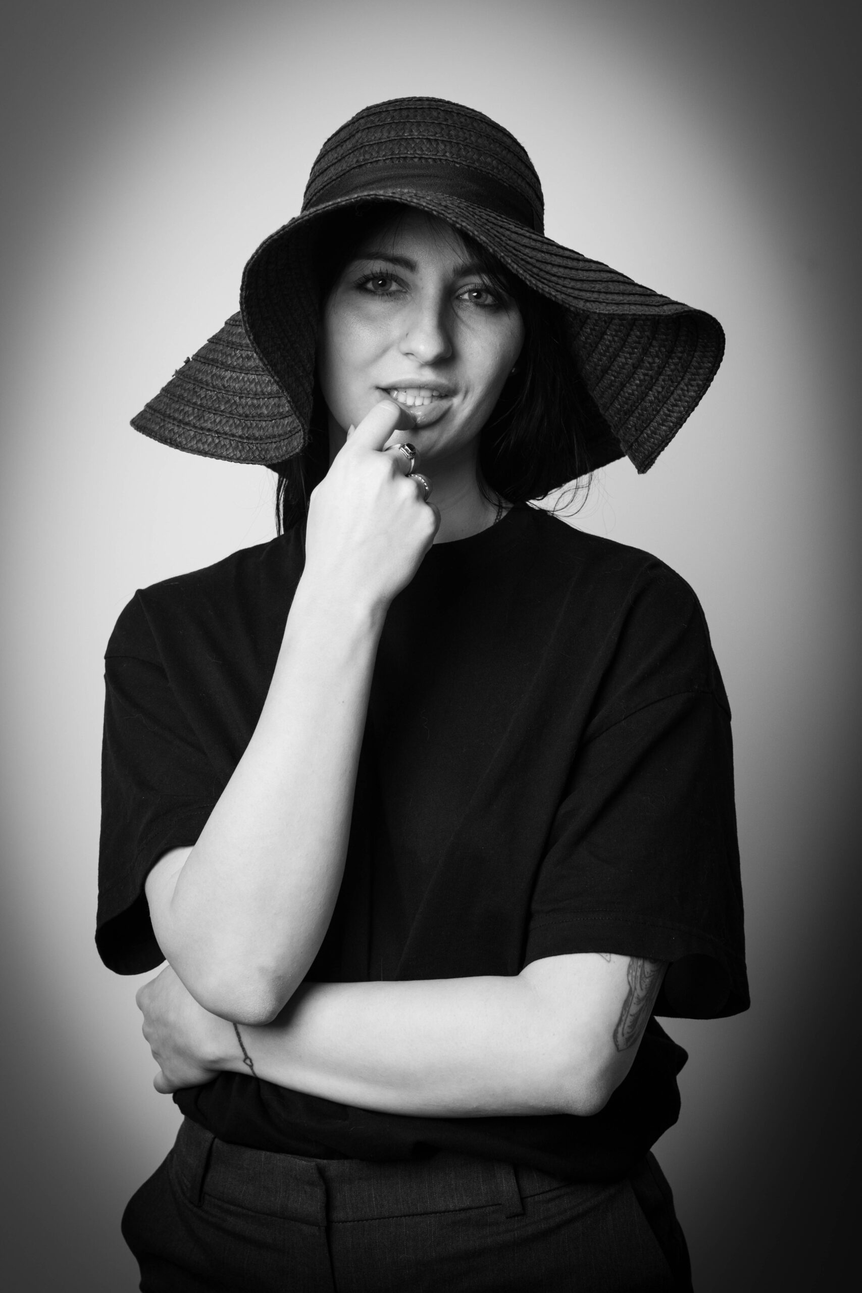 Czarno-białe zdjęcie dziewczyny w kapeluszu i czarnej koszulce