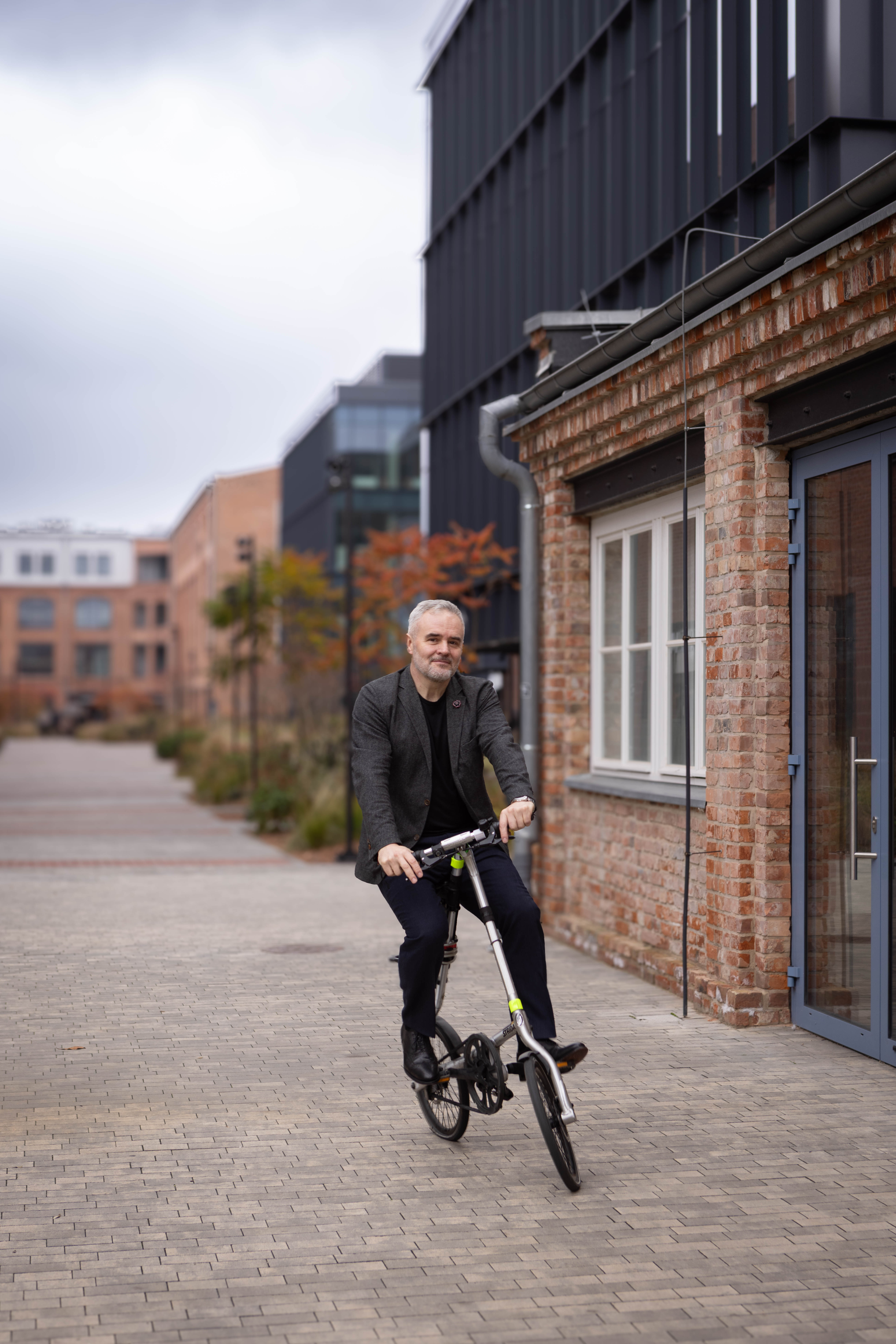Mężczyzna na rowerze na podwórku w przestrzeni loftowej